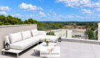 Sonnige Dachterrasse des Penthouse in Colonia de Sant Jordi mit weißer Lounge, Glasgeländer und Panoramablick.