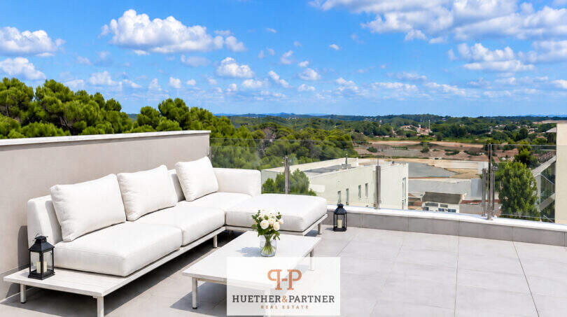 Sonnige Dachterrasse des Penthouse in Colonia de Sant Jordi mit weißer Lounge, Glasgeländer und Panoramablick.