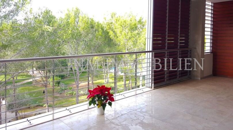 Terraza espaciosa con barandilla metálica, flor de Pascua y vistas a pinos verdes en Bendinat