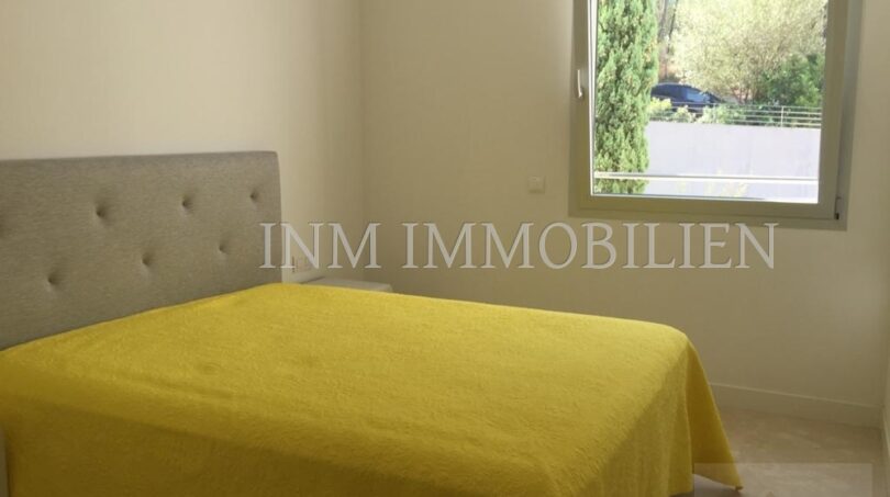 Dormitorio luminoso con cama amarilla y ventana con vistas al jardín en moderno ático en Bendinat