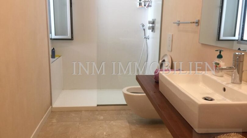 Moderno cuarto de baño del ático en Bendinat con ducha a ras de suelo, bidet y elegante lavabo.