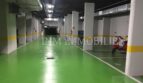 Garaje subterráneo del ático en Bendinat con suelo verde, plazas de aparcamiento y scooter rojo