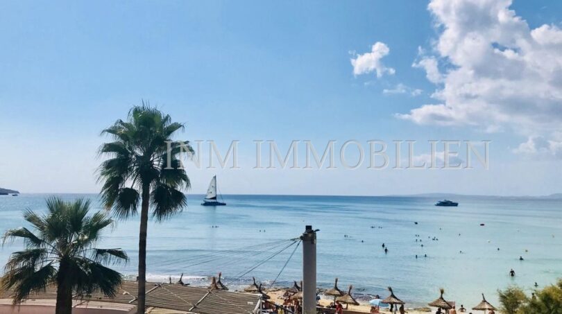 Strandpromenade El Arenal mit türkisblauem Meer, Palmen, Strandbar und Segelboot – Blick aus der Wohnung in erster Meereslinie.
