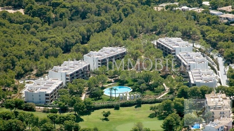 Aerial view of modern penthouse complex in Bendinat with pool, green spaces and pine forest