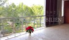 Spacious terrace of the penthouse apartment in Bendinat with stainless steel railing, wooden slats and green view