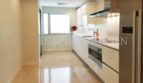 Modern fitted kitchen with white high-gloss fronts, Siemens appliances and marble floor in penthouse Bendinat