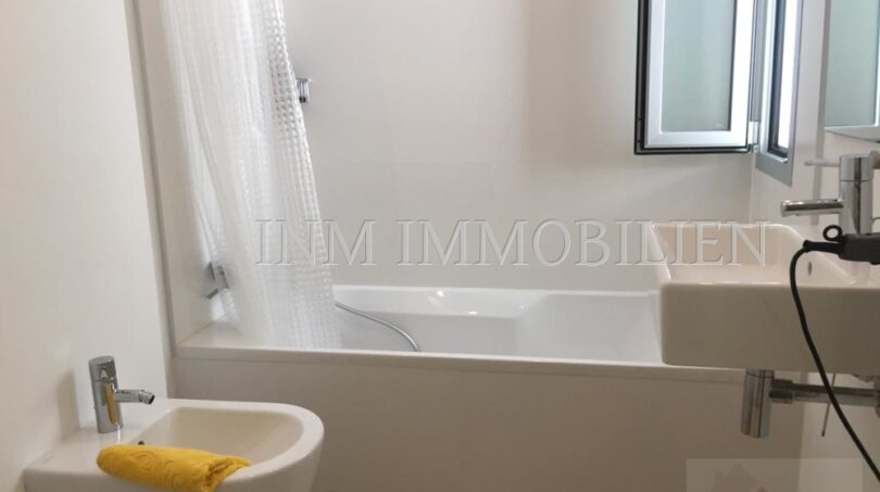 Bright bathroom of the penthouse apartment Bendinat with bathtub, bidet and sink in modern design.