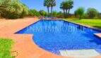 Large blue pool with terracotta tiles, loungers and palms of the finca near Campos