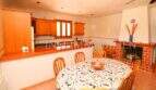 Spacious kitchen with dining area, wooden furniture, fireplace and kitchen unit of the finca near Campos with pool.