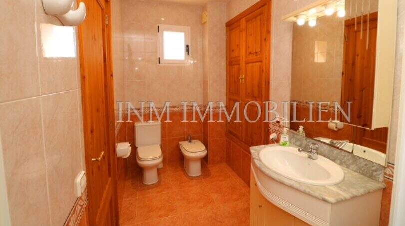 Bright bathroom of the finca near Campos with toilet, bidet, sink and wooden elements.