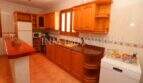 Spacious kitchen of Finca Campos with wooden cabinets, granite worktop and dishwasher