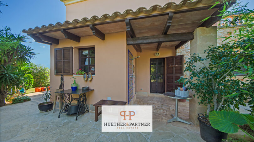 Terraza cubierta de la finca en Felanitx con encanto mediterráneo, vigas de madera y suelo de piedra natural