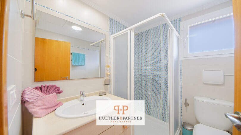 Helles Badezimmer mit Duschkabine, Waschbecken und WC im Haus in Cala Murada