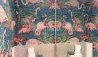 Gäste-WC mit auffälliger Flamingo-Tapete in Blau-Rosa, weißem WC und Spiegel in Maisonette-Dachgeschosswohnung Palma