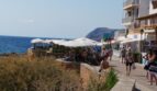 Strandpromenade in Cala Ratjada mit Restaurants, Meerblick und Felsenküste, nahe der Mietwohnung am Hafen.