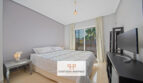 Helles Schlafzimmer der Mallorca-Wohnung mit Doppelbett, TV und Balkontür mit Palmenblick.