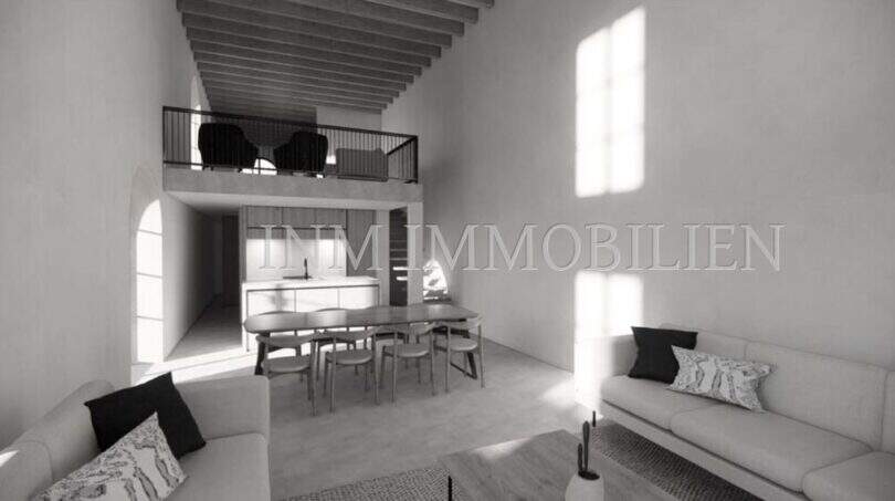 Sala de estar inundada de luz con galería, comedor y zona de cocina abierta de una finca rústica en Sóller.
