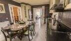 Küche mit Esstisch aus Marmor, schwarzen Einbaugeräten und Zugang zum Wohnbereich in Villa Marratxí