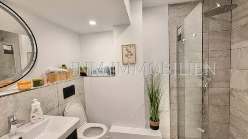 Modernes Badezimmer mit Glasdusche, WC und Waschtisch in renovierter Mietwohnung an der Playa de Palma