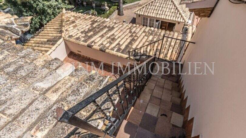 Außentreppe mit Schmiedeeisen-Geländer, mediterrane Ziegeldächer und Gartenblick der Villa in Marratxí