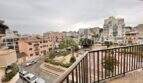 Balkon mit Metallgeländer und Blick auf Plaza, Wohngebäude und belebte Straße in Ses Cadenes, Palma