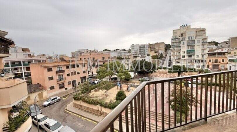 Balkon mit Metallgeländer und Blick auf Plaza, Wohngebäude und belebte Straße in Ses Cadenes, Palma