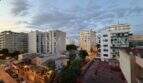 Abendlicher Blick vom Balkon über die Dächer von El Arenal, Palma de Mallorca, mit belebter Straße und Stadtpanorama.