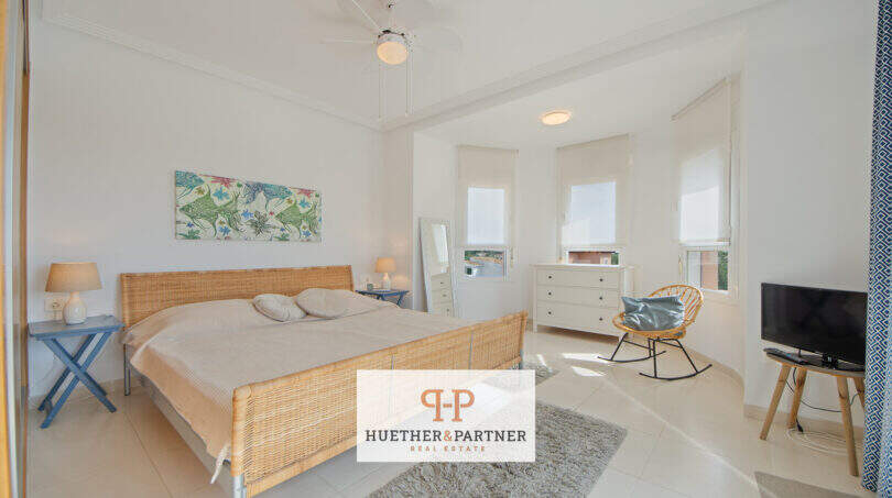Helles Schlafzimmer mit Rattanbett, Deckenventilatoren und großen Fenstern im Haus in Cala Murada.