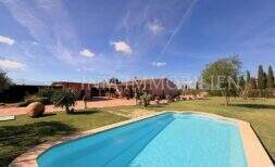 Chalet Marratxí: Vista exterior con gran piscina, césped cuidado y jardín mediterráneo bajo cielo azul.