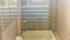Helles Badezimmer der Mietwohnung in Cala Ratjada mit Badewanne, Glasabtrennung, WC und Waschbecken