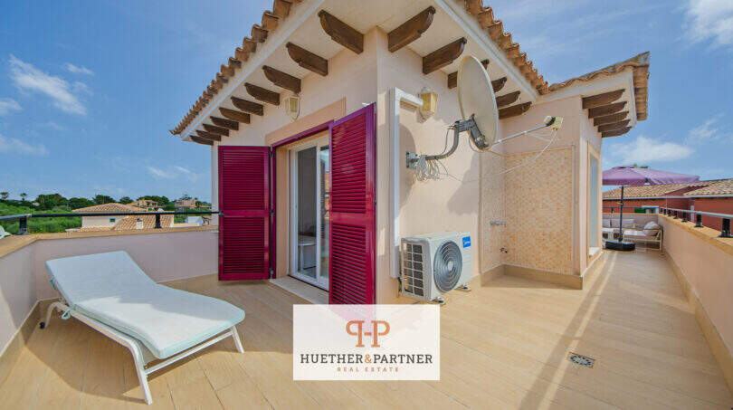 Sonnige Dachterrasse mit Holzdielen, Liegestuhl, roten Fensterläden und Klimaanlage in Cala Murada