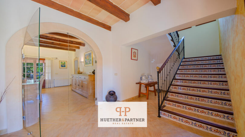 Eingangsbereich der Finca Felanitx mit Treppe, Rundbogen und handbemalten Keramikfliesen auf den Stufen.