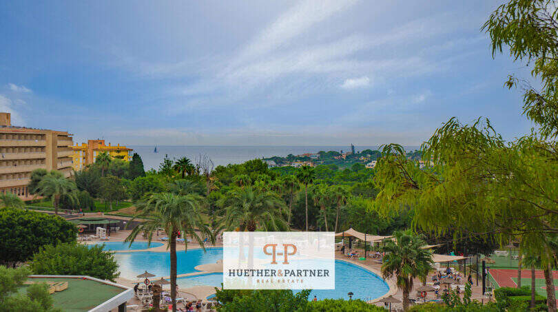 Weitläufige Poolanlage mit Palmen und Meerblick in der Ferienanlage Cales de Mallorca