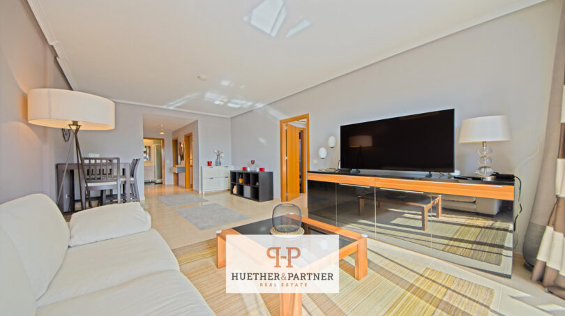 Helles Wohnzimmer der Mallorca-Wohnung mit großem TV, modernen Möbeln, Essbereich und offener Raumgestaltung.