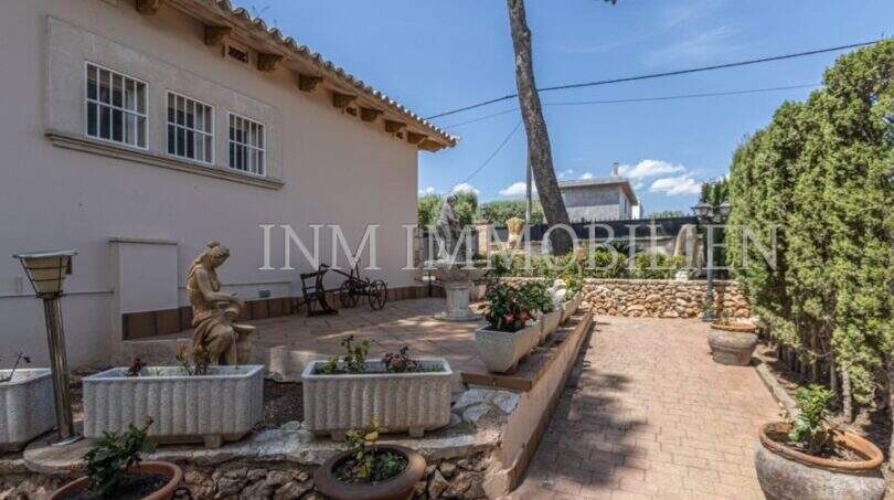 Gepflegter Außenbereich der Villa in Marratxí mit Steinskulpturen, Springbrunnen, Pflanzenkübeln und mediterranem Garten.