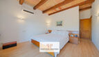 Dormitorio luminoso de la finca Felanitx con cama doble, techo de vigas de madera y aire acondicionado