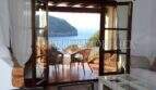 Wohnzimmer mit Terrassenzugang und Panoramablick auf die Bucht von Port de Sóller mit Leuchtturm