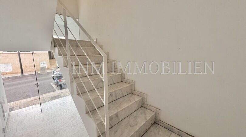 Helles Treppenhaus mit Marmorstufen und weißem Geländer in moderner Maisonette-Dachgeschosswohnung in Palma