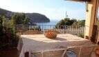 Sonnige Terrasse mit Korbmöbeln und atemberaubendem Meerblick auf die Bucht von Port de Sóller
