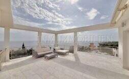 Weitläufige Dachterrasse mit Lounge-Bereich, Glasgeländer und spektakulärem Meerblick in Cala Pi.