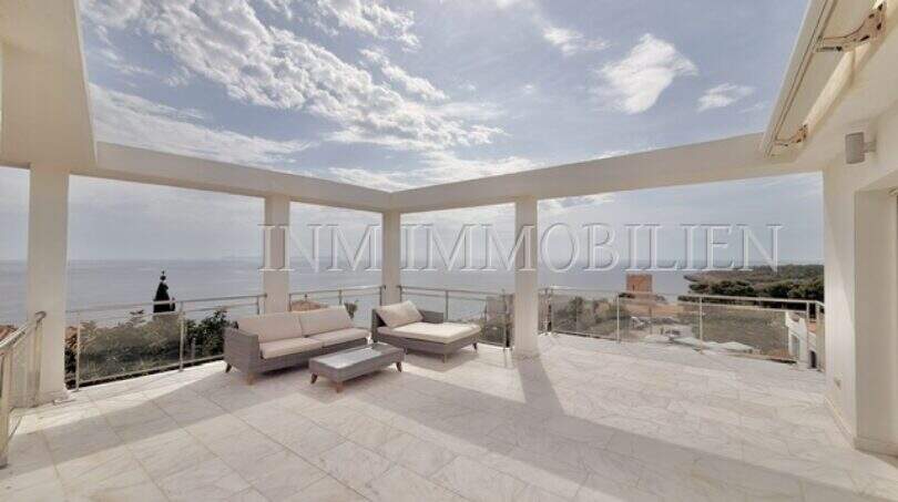 Weitläufige Dachterrasse mit Lounge-Bereich, Glasgeländer und spektakulärem Meerblick in Cala Pi.