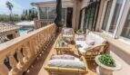 Sonnige Terrasse der Villa in Marratxí mit Rattanmöbeln, Balustrade und Blick auf den Pool.