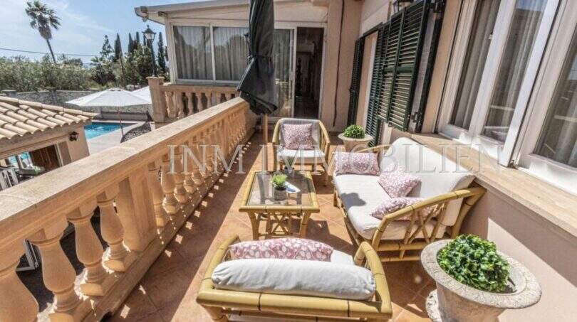 Sonnige Terrasse der Villa in Marratxí mit Rattanmöbeln, Balustrade und Blick auf den Pool.