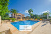 Finca Felanitx: Piscina mediterránea con terraza de piedra natural, palmeras y casa de campo rústica bajo cielo azul