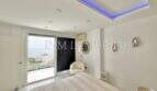Helles Schlafzimmer mit indirekter LED-Beleuchtung, Meerblick-Terrasse und modernem Design im Penthouse Cala Pi.
