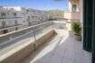 Balcón soleado con barandilla de vidrio y vistas a edificios vecinos en apartamento moderno cerca del mar en Alcudia