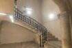 Escalera histórica con escalera de piedra curva, barandilla de hierro forjado y arco abovedado en la casa urbana de Llucmajor