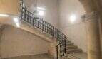 Escalera histórica con escalera de piedra curva, barandilla de hierro forjado y arco abovedado en la casa urbana de Llucmajor
