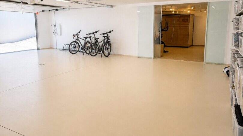 Geräumige Garage der Designvilla in Portixol mit Epoxidboden, Fahrradständer und angrenzendem Fitnessraum.