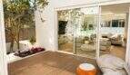 Sonnige Terrasse mit Holzboden und Glasschiebetüren zum eleganten Wohnzimmer der Designvilla in Portixol